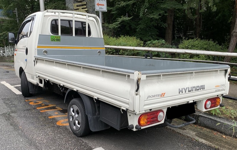 Hyundai H100'ün açık kasası arkadan görünüm; kapaklar kapalı, kasa tabanı düz ve boş.